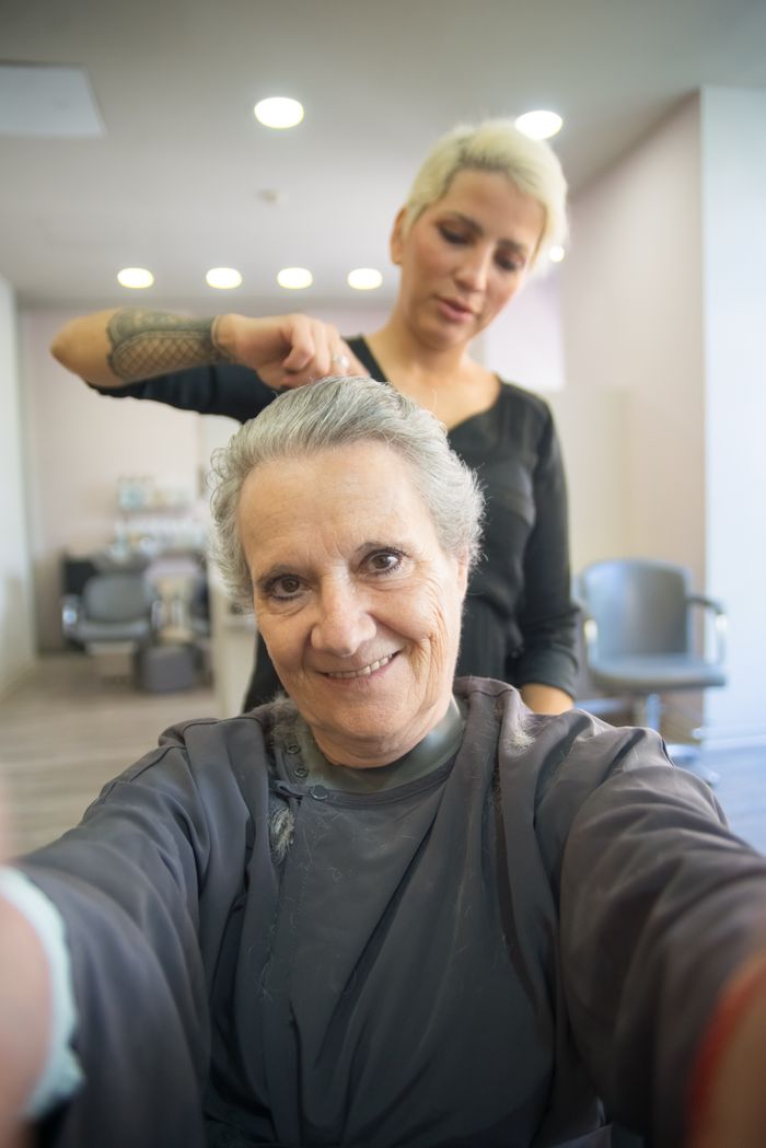 The Art of Drawing Readers In: Your attractive post title goes here Smiling senior woman with hairdresser in a salon. A joyful hair styling session indoors.